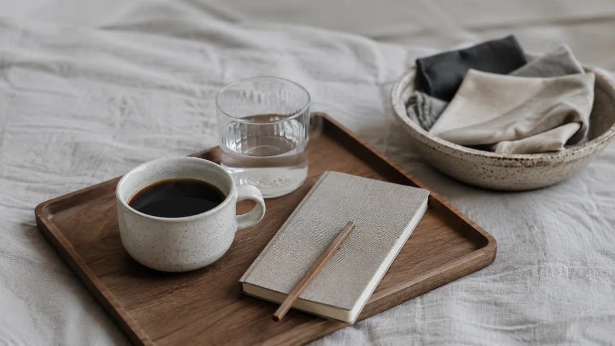 Simple morning tray with coffee, water and a small journal