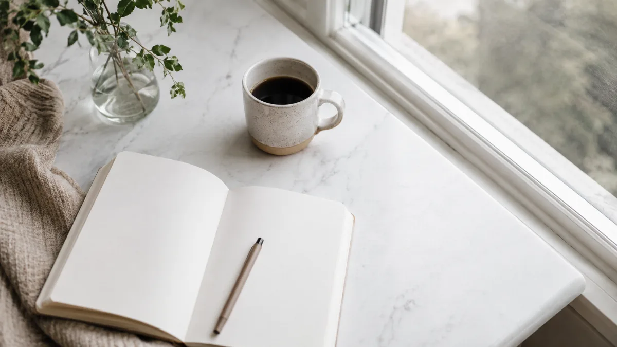 Bright morning scene with coffee and a notebook by a window